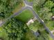 Bird's-eye view of home nestled among mature trees, with manicured lawn and paved roads at 629 Silver Trace Ct, Woodstock, GA 30189