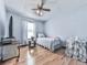 A simple bedroom featuring hardwood floors, a twin bed, neutral walls, and a large window for natural light at 629 Silver Trace Ct, Woodstock, GA 30189