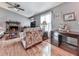 Comfortable living room featuring hardwood floors, a fireplace, neutral paint, and a ceiling fan at 629 Silver Trace Ct, Woodstock, GA 30189