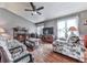Inviting living room with hardwood floors, ceiling fan, fireplace, floral furniture, and ample natural light at 629 Silver Trace Ct, Woodstock, GA 30189