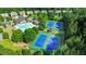 Aerial view showcasing the community pool and tennis courts surrounded by trees at 1820 Primrose Park Rd, Sugar Hill, GA 30518
