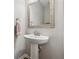 Clean bathroom features a pedestal sink, framed mirror, and warm neutral walls at 1820 Primrose Park Rd, Sugar Hill, GA 30518