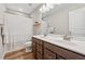 Bright bathroom features a double sink vanity, wood-look flooring, and tub and shower combination at 1820 Primrose Park Rd, Sugar Hill, GA 30518