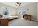 Neutral bedroom featuring two large windows, a ceiling fan, and simple furnishings at 1820 Primrose Park Rd, Sugar Hill, GA 30518
