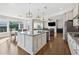 Open concept kitchen with island, stainless steel appliances and adjacent dining area with ample natural light at 1820 Primrose Park Rd, Sugar Hill, GA 30518