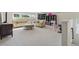 Spacious carpeted living room with sofas, ottoman, shelving, and an exercise area at 1820 Primrose Park Rd, Sugar Hill, GA 30518