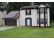 Inviting two-story home featuring solar panels, brown trim, a well-manicured lawn, and an attached garage at 3255 Hunters Crossing Pt, Lithonia, GA 30038
