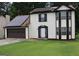 Two-story home shows solar panels and a two-car garage with a traditional suburban aesthetic at 3255 Hunters Crossing Pt, Lithonia, GA 30038