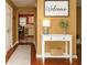 Inviting hallway with a white console table, decor, and view into the adjacent kitchen at 3255 Hunters Crossing Pt, Lithonia, GA 30038