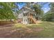 Spacious home's backyard with green lawn and trees, featuring a deck, perfect for outdoor entertaining at 3541 Wilton Ave, Atlanta, GA 30340