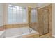 Bathroom with a tiled jacuzzi tub and glass enclosed shower near a frosted window at 3541 Wilton Ave, Atlanta, GA 30340