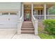 Inviting front porch with brick steps and columns, with a view of the garage and a neatly trimmed lawn at 3541 Wilton Ave, Atlanta, GA 30340