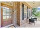 Charming front porch featuring brick detail, a cozy seating area, and a welcoming entryway with a wooden door at 3541 Wilton Ave, Atlanta, GA 30340