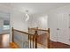 Upstairs hallway featuring hardwood floors, decorative railing, and modern lighting fixture at 3541 Wilton Ave, Atlanta, GA 30340
