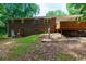 View of the back of the home, which features a red brick exterior and a large wooden deck, sitting on a sloping lot at 514 Macedonia Forest Circle Cir, Canton, GA 30115