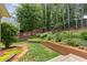 Picturesque backyard with lush greenery, a retaining wall, and a mix of fences for a private outdoor space at 2905 Ivey Ridge Ln, Roswell, GA 30076