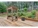 A cozy wooden deck featuring a bench swing under a pergola, and planters for a relaxing outdoor retreat at 2905 Ivey Ridge Ln, Roswell, GA 30076