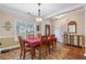 Well-lit dining space with a view of the front yard and classic furnishings, complemented by hardwood floors at 2905 Ivey Ridge Ln, Roswell, GA 30076