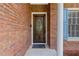 Elegant front door with a glass insert and a welcoming black mat, framed by brick walls at 2905 Ivey Ridge Ln, Roswell, GA 30076