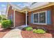 Close-up of a brick home showcasing the entryway with blue shutters and landscaped details at 2905 Ivey Ridge Ln, Roswell, GA 30076