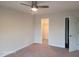 A cozy bedroom featuring neutral walls, plush carpet, ceiling fan, and a convenient walk-in closet at 303 Tara Commons Cir, Loganville, GA 30052