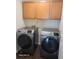 Well-equipped laundry room with modern washer and dryer, and wood cabinets for ample storage space at 303 Tara Commons Cir, Loganville, GA 30052