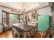 Bright dining room with hardwood floors and rustic wooden table and green refrigerator at 3861 Riding Sw Trl, Powder Springs, GA 30127