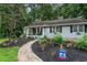 Landscaped front yard with mulch beds, flowers, and a walkway leading to the charming home at 3861 Riding Sw Trl, Powder Springs, GA 30127
