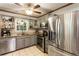 Modern kitchen with stainless steel appliances, granite counters, coffee bar, and tile flooring at 3861 Riding Sw Trl, Powder Springs, GA 30127