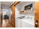 Convenient laundry room featuring modern appliances, ample shelving, and a rustic barn door at 3861 Riding Sw Trl, Powder Springs, GA 30127