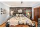 Comfortable main bedroom with rustic accent wall, hardwood floors, and natural lighting at 3861 Riding Sw Trl, Powder Springs, GA 30127
