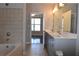 Bathroom includes double sinks, a soaking tub, and neutral tile at 400 17Th Nw St # 2412, Atlanta, GA 30363