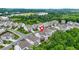Aerial view of a townhouse community with trees and green space in a suburban setting at 4110 Morgan Elizabeth Way, Cumming, GA 30041