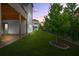 Beautiful, fully-sodded backyard featuring a black aluminum fence and mature tree at dusk at 4110 Morgan Elizabeth Way, Cumming, GA 30041