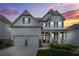 Attractive two-story home with a covered front porch under a colorful sunset sky at 4110 Morgan Elizabeth Way, Cumming, GA 30041