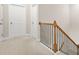 Hallway featuring carpet flooring, wood and iron railing, and white doors at 4110 Morgan Elizabeth Way, Cumming, GA 30041