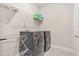Laundry room featuring dark washer and dryer with wire shelf and drying rack at 4110 Morgan Elizabeth Way, Cumming, GA 30041