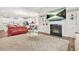Open-concept living room with a fireplace, red sofa, and views into the kitchen area at 4110 Morgan Elizabeth Way, Cumming, GA 30041