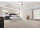 Spacious main bedroom with tray ceiling, carpet, and access to a luxurious bathroom at 4110 Morgan Elizabeth Way, Cumming, GA 30041