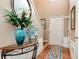 Hallway featuring hardwood floors, a decorative table with floral arrangement, and neutral wall colors at 914 Wenham Ln, Lawrenceville, GA 30044