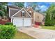 View of the front exterior featuring a driveway and attached two-car garage, showcasing the home's architectural details at 914 Wenham Ln, Lawrenceville, GA 30044