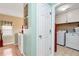 Hallway with access to a laundry room featuring modern appliances and ample storage space at 914 Wenham Ln, Lawrenceville, GA 30044