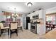 Eat-in kitchen featuring stainless steel appliances, white cabinetry, and a view of the dining area at 914 Wenham Ln, Lawrenceville, GA 30044