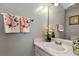 Cozy powder room with floral decor, a white vanity, and a framed mirror at 914 Wenham Ln, Lawrenceville, GA 30044