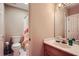 Standard bathroom featuring a sink, toilet, mirror, and a pink and orange striped shower curtain at 110 Boulder Dr, Roswell, GA 30075