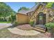 Home's entrance features a stone facade and a dark wood door framed by green bushes, for warm curb appeal at 110 Boulder Dr, Roswell, GA 30075