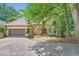Charming home featuring a stone front, two-car garage and a lush, tree-lined landscape, inviting curb appeal at 110 Boulder Dr, Roswell, GA 30075