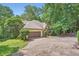 Traditional home boasts mature trees, a stone accent wall, and a two-car garage, all adding to its charm at 110 Boulder Dr, Roswell, GA 30075