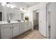 Bathroom with double sinks, tile floors, white cabinets, and a walk-in closet at 1935 Cobblestone Ne Cir, Brookhaven, GA 30319