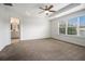 Bright primary bedroom boasting a ceiling fan, tray ceiling, and a view to a full bath at 1935 Cobblestone Ne Cir, Brookhaven, GA 30319